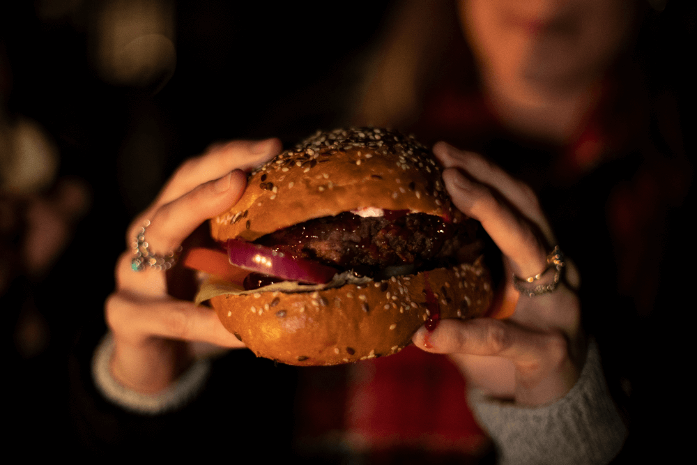 A large christmas burger being held