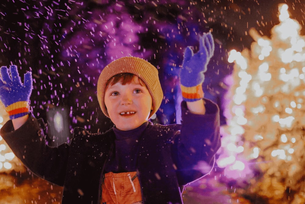 A little boy enjoys 'snow' at glow Marwell, Marwell Zoo