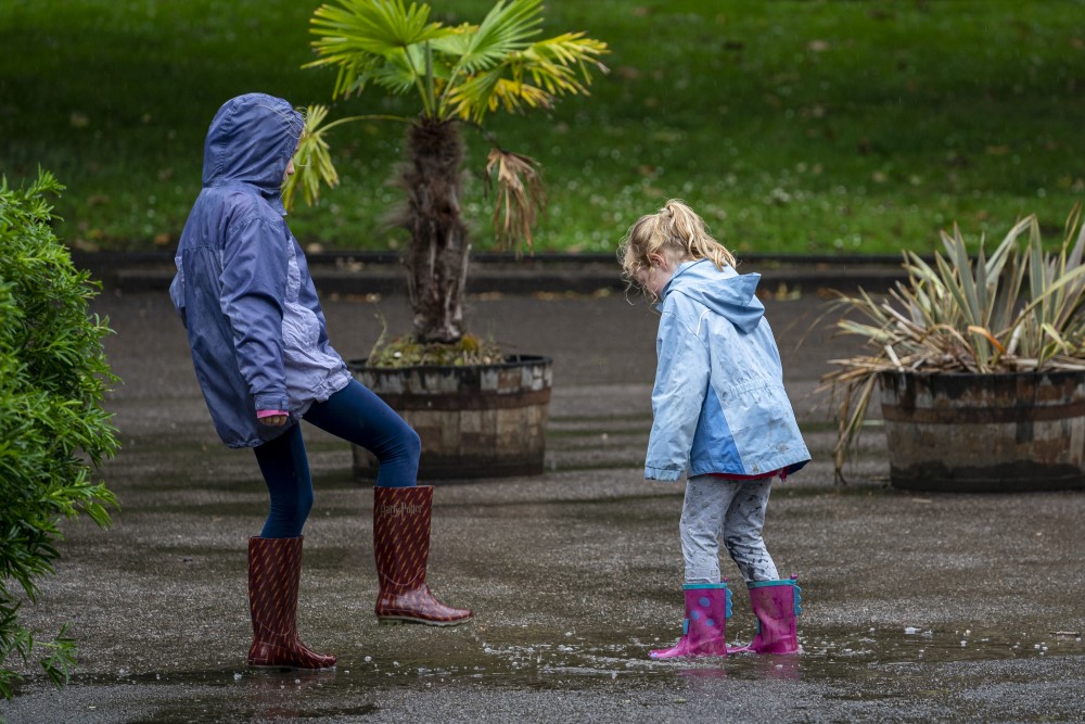 Children jump in puddles in the rain at Marwell Zoo in Hampshire