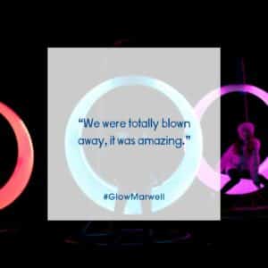 Children sit on colourful light-up moon-shaped swing chairs. Text int he middle reads: "We were totally blown away, it was amazing." #Glow Marwell