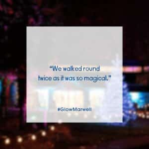 A colourful image of Marwell Zoo's gift shop lit up by christmas trees and lights. Text in the middle reads: "We walked round twice as it was so magical." #Glow Marwell