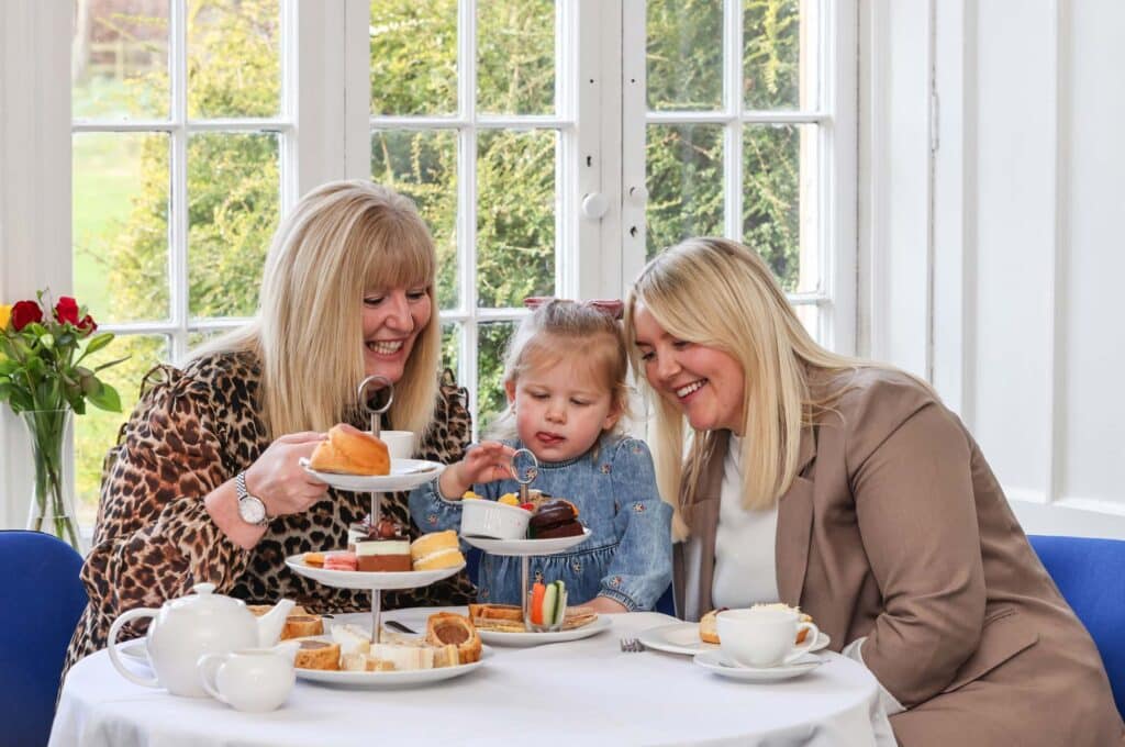 Two women and a child eating afternoon tea at Marwell Hall