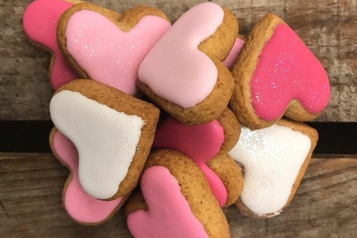 Heart-shaped biscuits with pink icing by Little Bee Bakery