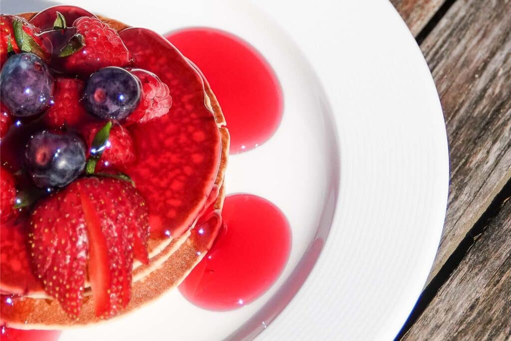 A stack of American pancakes with berries at The Keeper's Kitchen at Marwell Zoo