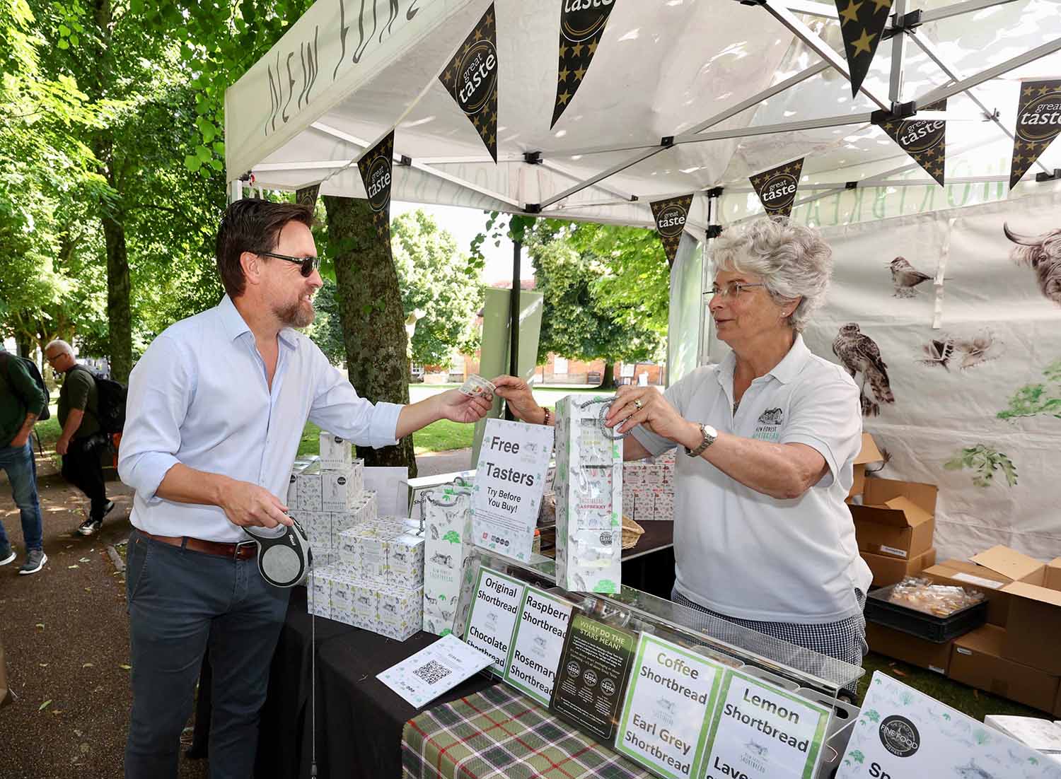A man buys shortbread from a New Forest Shortbread stall holder at a Hampshire Food Festival