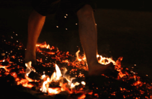 A person walks over flaming hot coals at a Blaze Firewalk