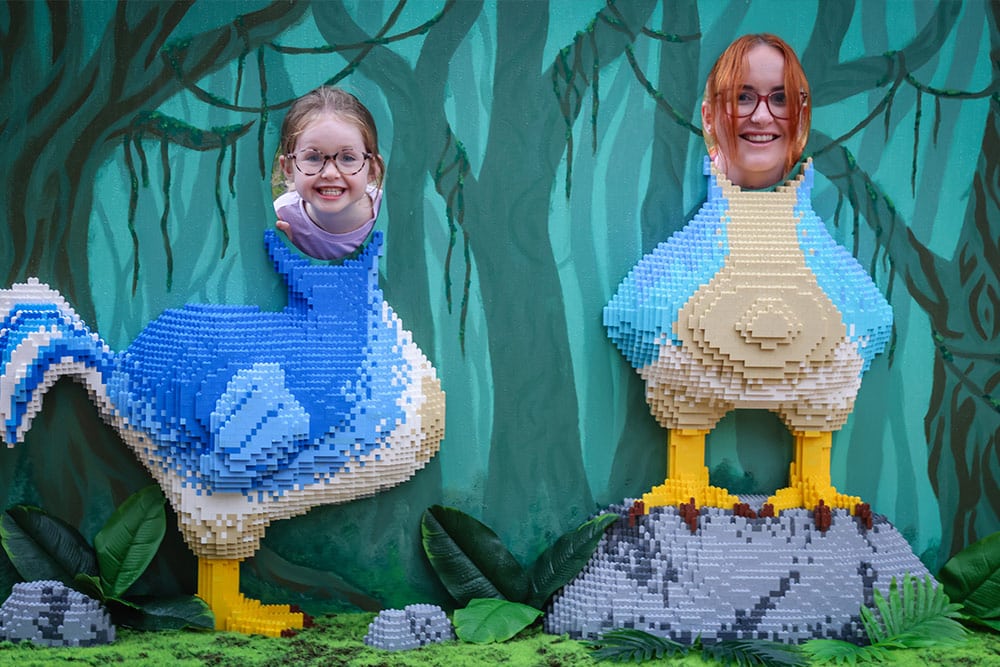 Two people smile in a dodo photo opportunity made of toy bricks at Marwell Zoo's Extinction event