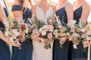 A bridal party holding flower arrangements