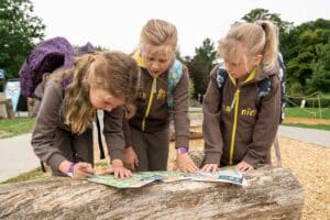 Three brownies complete a worksheet at the Scouting the Zoo event at Marwell Zoo