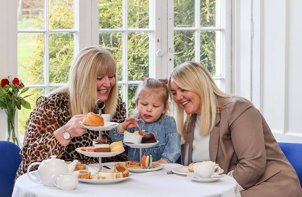 Two women and a child enjoying afternoon tea at Marwell Hall