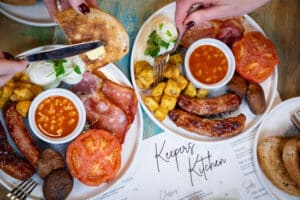 Two plates of cooked breakfast and a Keepers Kitchen menu at Marwell Zoo