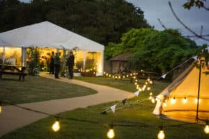 The Secret Garden Marquee and a bell tent at Marwell Zoo, lit up with fairy lights
