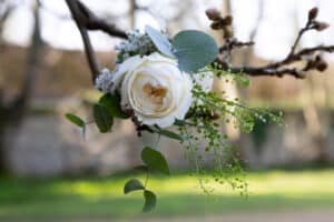 A floral wedding decoration on a branch outside Marwell Hall