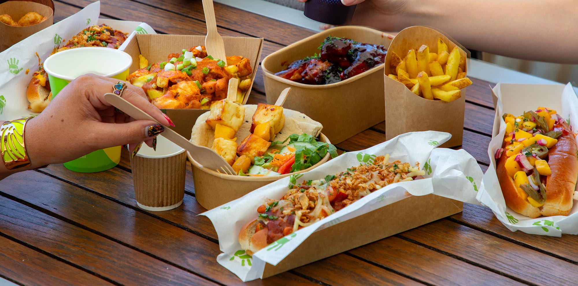 Guests enjoying a selection of food from Cafe Graze, including hot dogs, fries and halloumi skewers