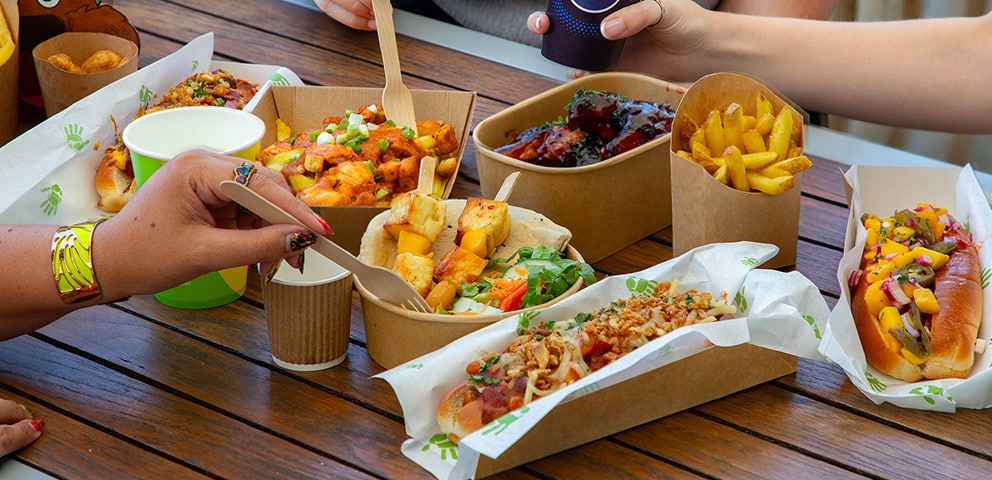 Guests enjoying a selection of food from Cafe Graze, including hot dogs, fries and halloumi skewers