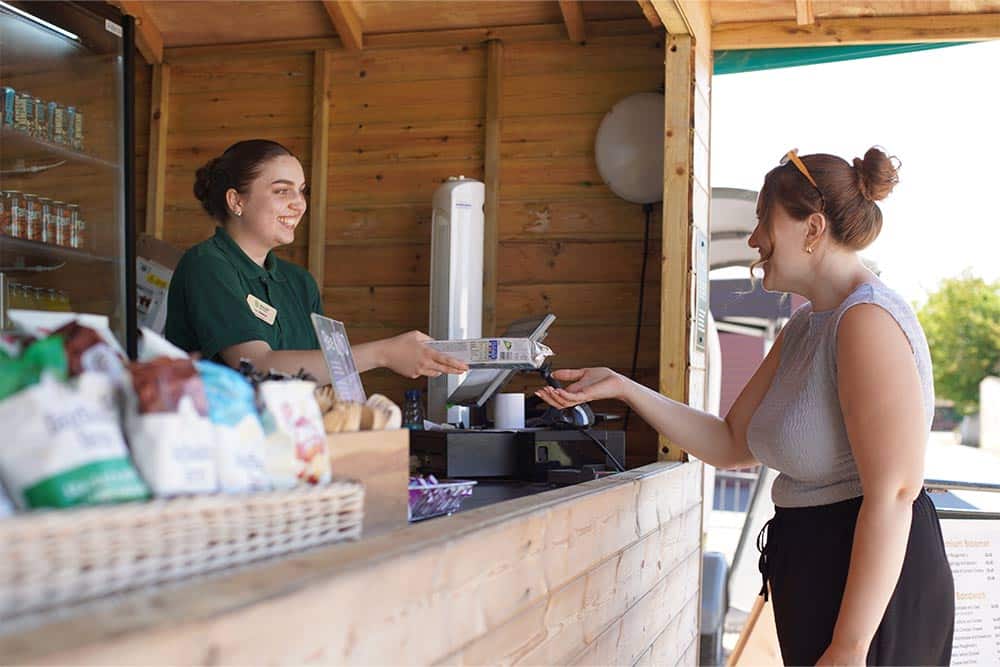 A guest purchases food from The Outpost at Marwell Zoo